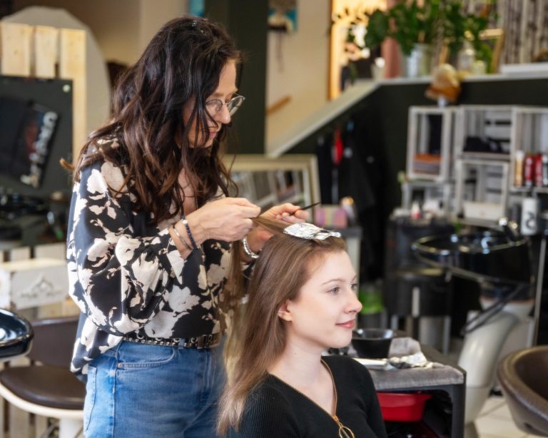 Professionelle Haarfarbe & Haarschnitte bei Ute’s Haarstudio Northeim. Friseurin Heike trägt Haarfarbe bei einer Kundin im Salon auf.
