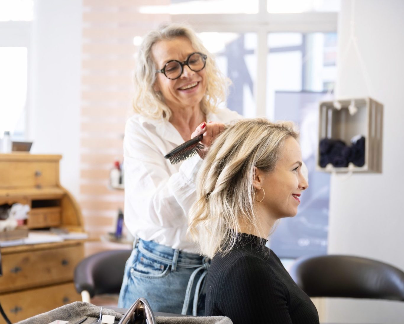 Individuelles Haarstyling bei Ute’s Haarstudio in Northeim. Friseurmeisterin Ute stylt die Haare einer Kundin im Salon in Northeim.
